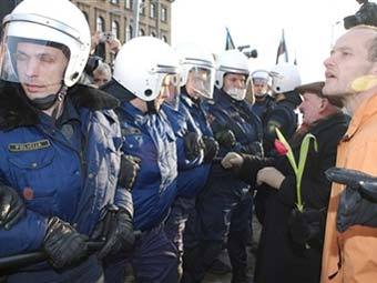 Полиция пытается остановить шествие в Риге. Фото AFP